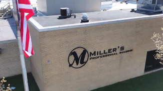 outside of gray industrial building with American flag in top left corner