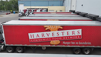 Image of semi trucks and trailers that have the Harvesters logo on them